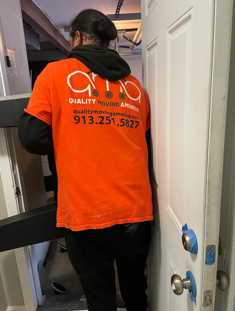 QMA crew member in branded orange t-shirt on a Kansas City job